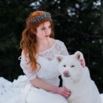 Mariée rousse dans la neige avec un chien blanc