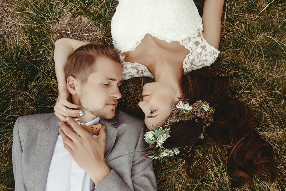 Couple mariés allongés dans l'herbe