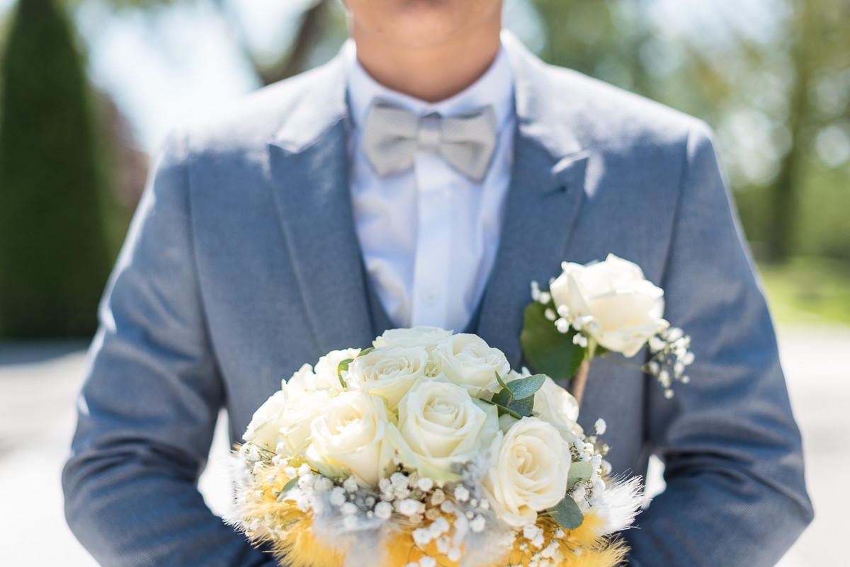 Le marié bleu et gris avec le bouquet