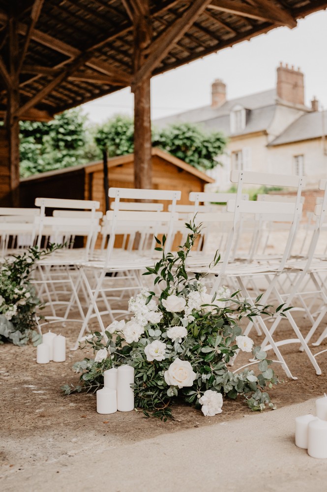 décoration florale blanche et verte avec des bougies pour une allée nuptiale